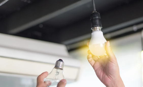 A person is replacing a light bulb with LED lighting