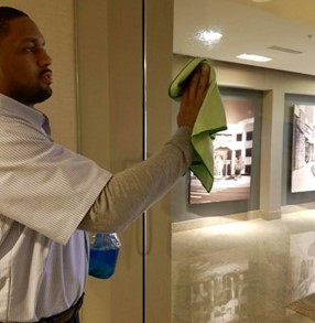 Continuum Day Porter cleaning glass in an office building